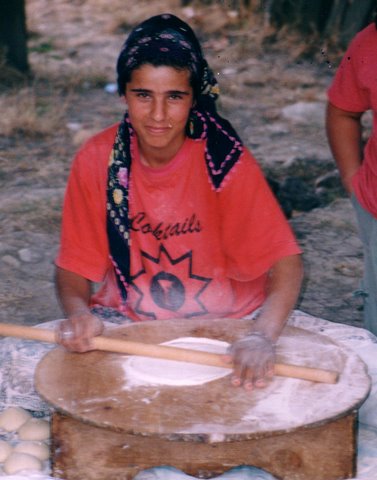 village woman rolling out the dough to make bread